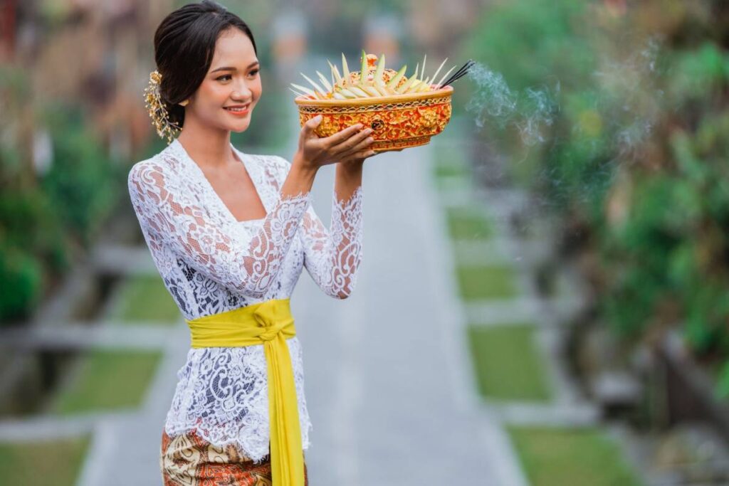Balinese woman in traditional kebaya holding an offering in Sanur