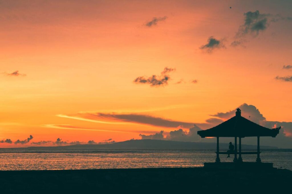 Silhouette of gazebo by the ocean during sunset in Sanur, Bali