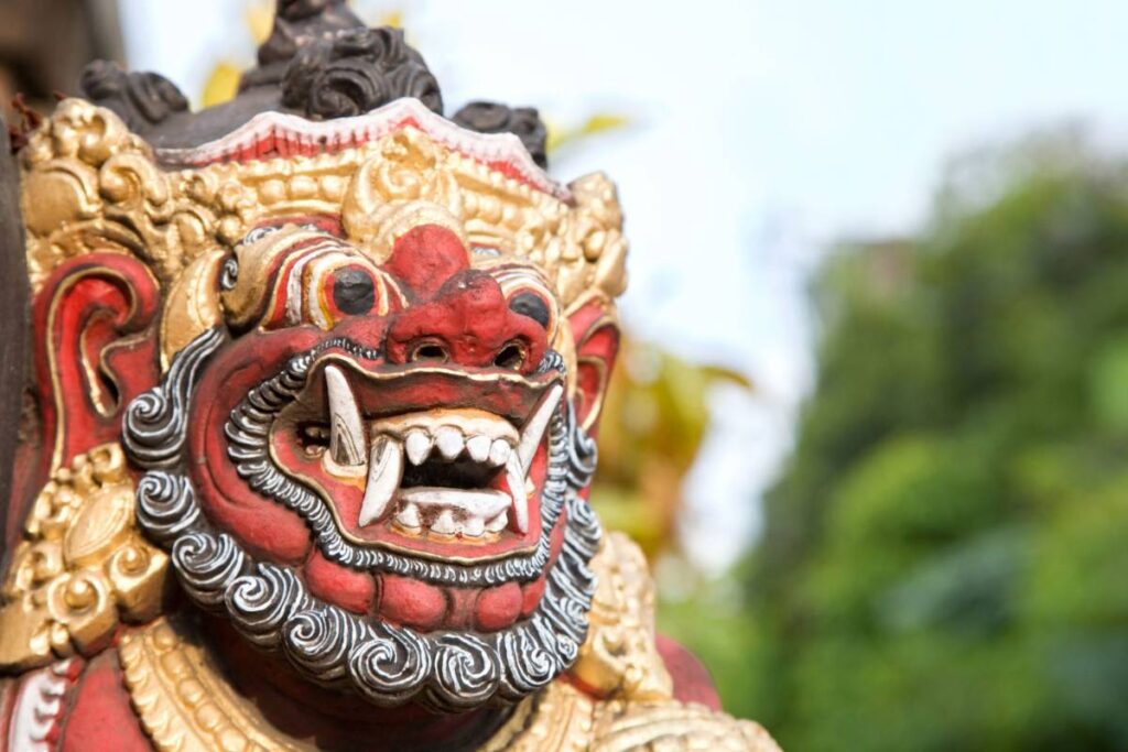Close-up of a red Balinese Barong statue with ornate gold and black details