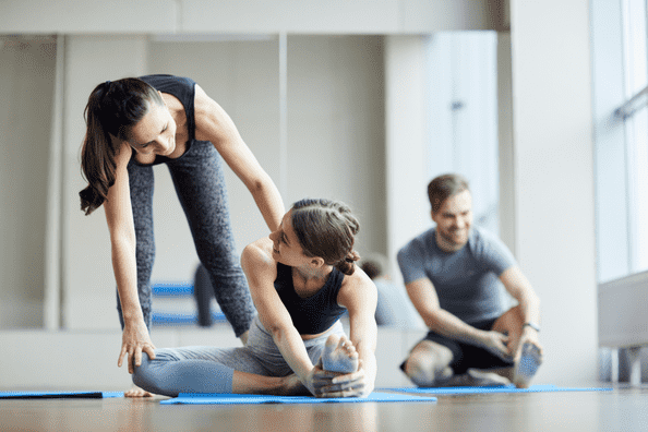 Yoga students receiving advanced instruction in a training session