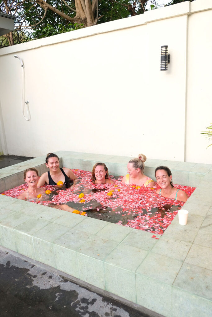 Group of retreat participants enjoying a relaxing flower bath in Bali.